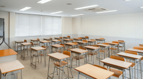 empty brown and metal classic classroom desks lined up in 6 rows 