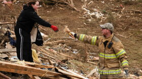 Volunteer firefighter Aaron Stamper and Olivia Gronlund pick through debris looking for personal belongings for their friends Beverly and Ronnie Bowman whose house was destroyed on Opossum Hollow Road.