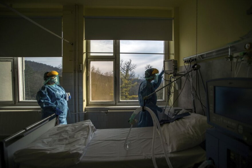 medical staff members check a ventilator