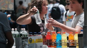 A woman buys a bottle of water during a heat wave in Central Park in New York City.