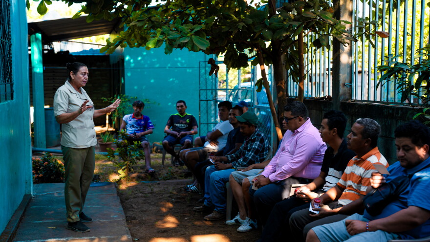 Sonia Lazo, a local health promoter, explains the CURE study to male residents in Jiquilisco, El Salvador, January 27, 2026.