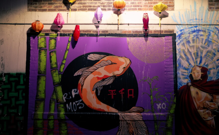 A pigeon perches above a mural in the alleys of downtown Sioux City.