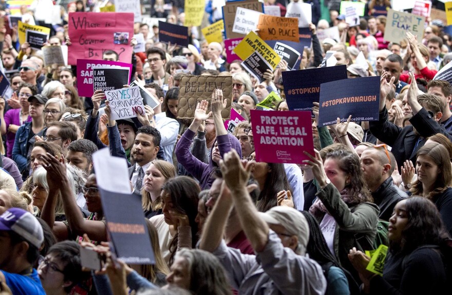 Protesters hold up #stopkavanaugh signs at the rally. (Robin Lubbock/WBUR)