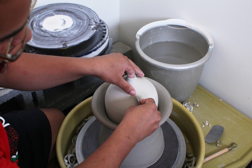 Kahlil Irving perfects the shape of one vase, nestled into another clay cylinder.  