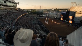 The interior of a large football stadium with pyrotechnics and a large crowd.