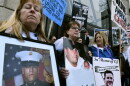 Kathleen Scarpone, left, of Kingston, N.H., and Cheryl Juaire, second from left, of Marlborough, Mass., protest in front of the Arthur M. Sackler Museum, at Harvard University, April 12, 2019, in Cambridge, Mass. Scarpone, who lost her son to OxyContin addiction, and Juarie addressed three Sackler family members during a virtual U.S. Bankruptcy Court hearing, Thursday, March 10, 2022. (AP Photo/Josh Reynolds, File)