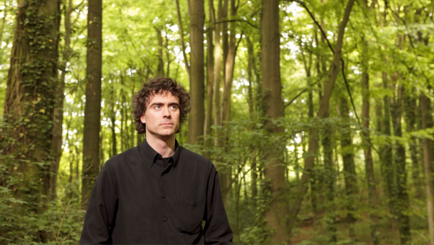 Paul Lewis stands in a green forest.