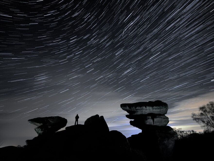 A man watches a meteor during the Geminid meteor shower over Brimham Rocks in North Yorkshire.