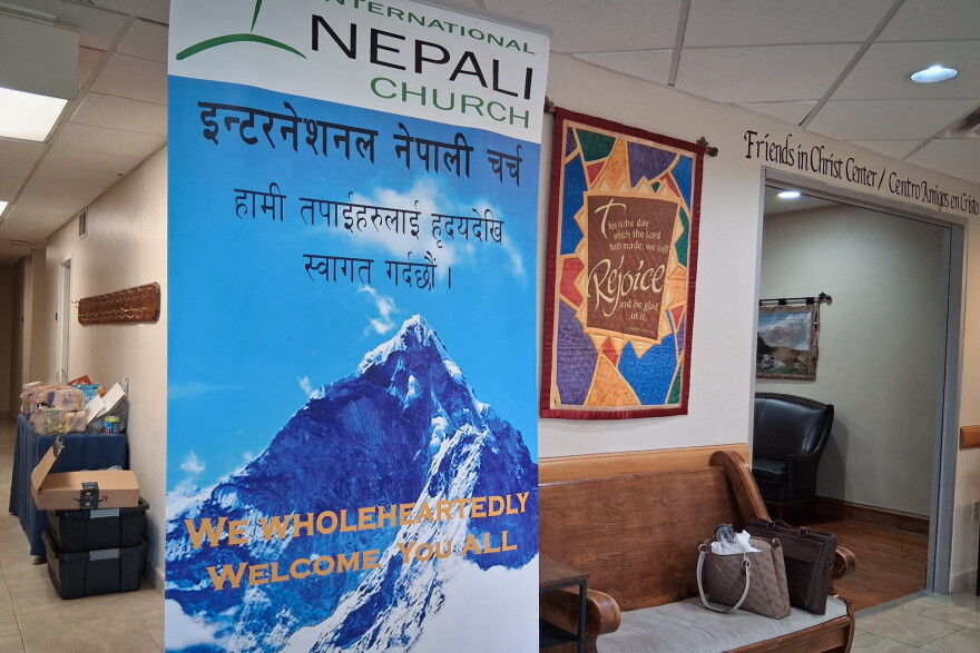 A blue and white banner in a church lobby that reads "International Nepali Church"