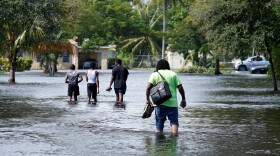 Residents walk a flooded street to reach their homes, Monday, Nov. 9, 2020 in Fort Lauderdale, where Tropical Storm Eta caused severe flooding in areas already saturated from previous downpours.