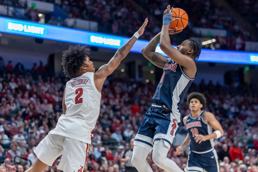 Arizona guard Jaden Bradley (0) shoots against Alabama guard Aden Holloway (2) during the second half of an NCAA college basketball game, Saturday, Dec. 13, 2025, in Birmingham, Ala. (AP Photo/Vasha Hunt)