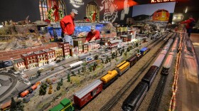 Volunteers Dick Cooper, left and Karl Bitter work to fix a train derailment inside Union Station's model trail gallery.