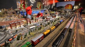 Volunteers Dick Cooper, left and Karl Bitter work to fix a train derailment inside Union Station's model trail gallery.