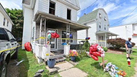 Jay Conden stands at the home on Bennett St in Luzerne is the site of a fatal fire of a 15 year-old, community members have left toys and balloons in memory of the boy.
