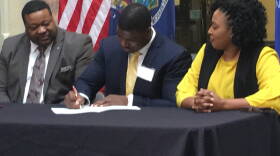 Rochester City Councilman Willie J. Lightfoot (Left), Greater Rochester Chamber of Commerce's Adrian Hale (Center) and Rochester Mayor Lovely Warren (Right) signed a pledge to further efforts for racial healing in Rochester.