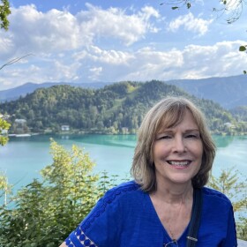 Marilyn Mascaro stands in front of a body of water.