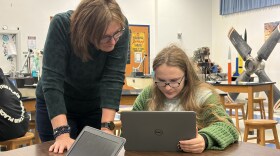 Middle school teacher Barbara Brock helps a student with classwork.