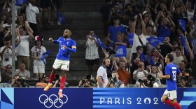 France's Alexandre Lacazette, left, celebrates after scoring his side's first goal during the men's Group A soccer match between France and the United States at the Velodrome stadium, during the 2024 Summer Olympics, Wednesday, July 24, 2024, in Marseille, France. (AP Photo/Daniel Cole)