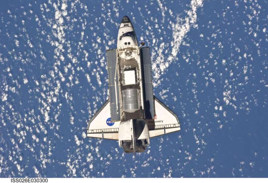 Backdropped by a blue and white part of Earth, space shuttle Discovery is featured in this image photographed by an Expedition 26 crew member as the shuttle approaches the International Space Station during STS-133 rendezvous and docking operations. Docking occurred at 2:14 p.m. (EST) on Feb. 26, 2011. Photo: NASA