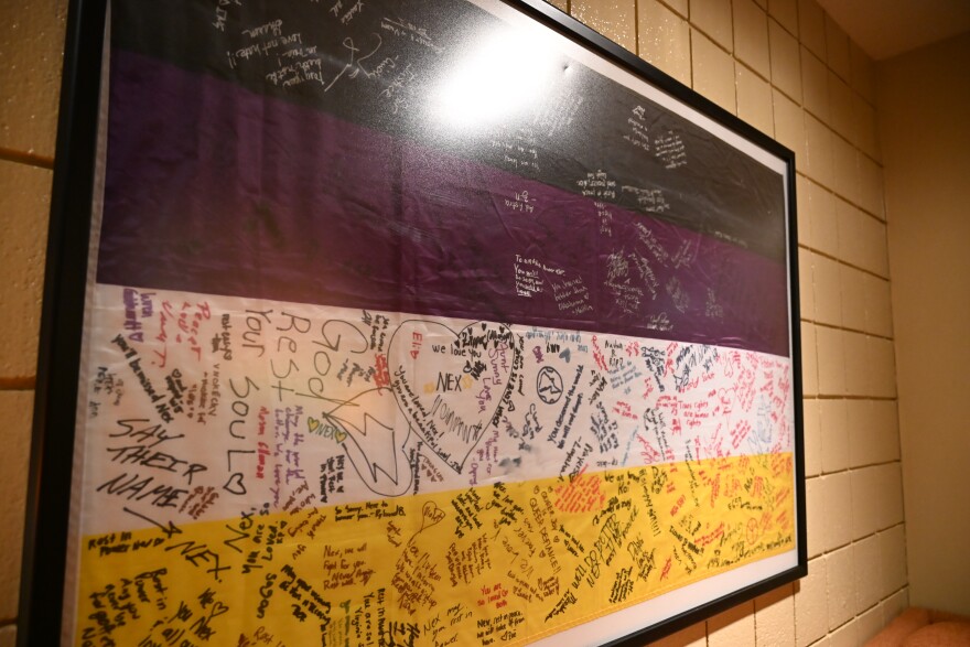 Signatures decorate a nonbinary flag on display in honor of Nex Benedict a former Youth Services of Tulsa attendee.