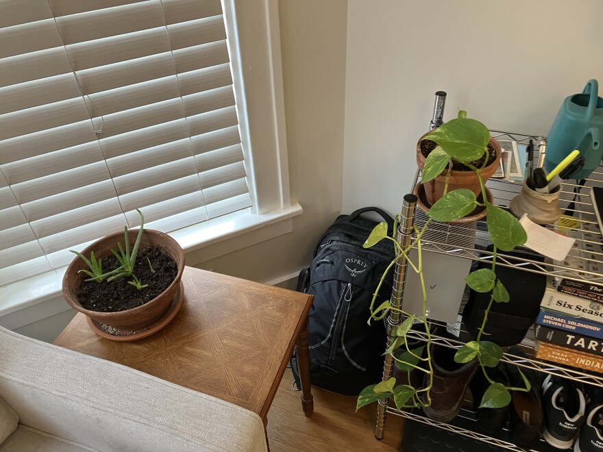 A black backpack sits in the corner of a room.