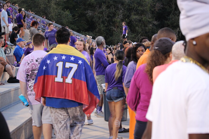 A student shows support for Sebastian Jimenez Peroza, 17, after his detention by immigration enforcement by wearing the Venezuelan flag on his back.