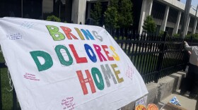 A banner tied to the fence outside the Kenneth B. Keating Federal Building reads "Bring Dolores Home," with added personal messages of support. The banner was hung on Tuesday, May 26, 2026. Inside the federal courthouse, Dolores Bustamante, a prominent Wayne County advocate for undocumented farmworkers, had a hearing over whether ICE violated her rights when agents detained her last month.