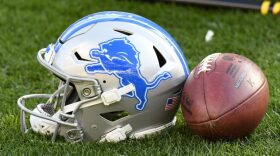 A Detroit Lions helmet sits beside a football on the sideline during the second half of an NFL preseason football game between the Pittsburgh Steelers and the Detroit Lions, Sunday, Aug. 28, 2022, in Pittsburgh.