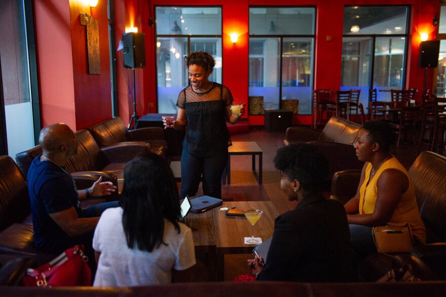 Nicole Muse-Dennis (center) has two jobs. By day she's a school teacher, and by night a manager at a bar in Charlotte. (Swikar Patel for NPR)