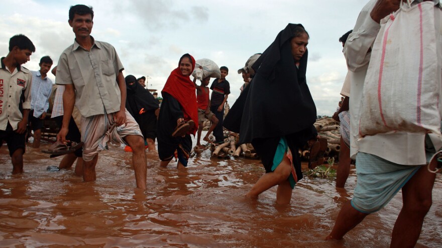 In the Cancun climate talks, officials will be discussing how rich countries can help poor countries, like Bangladesh, adapt to climate change. The low-lying nation has drawn up plans for how it would cope with rising sea levels, which are expected as a result of global warming. Here, people ford a flooded river near the port city of Chittagong.