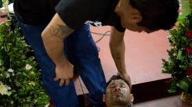 Carlos Montano, an ex-gang member, faints during prayer at San Salvador's Eben-ezer church.