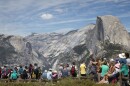 Crowds gather in front of a mountain backdrop. 