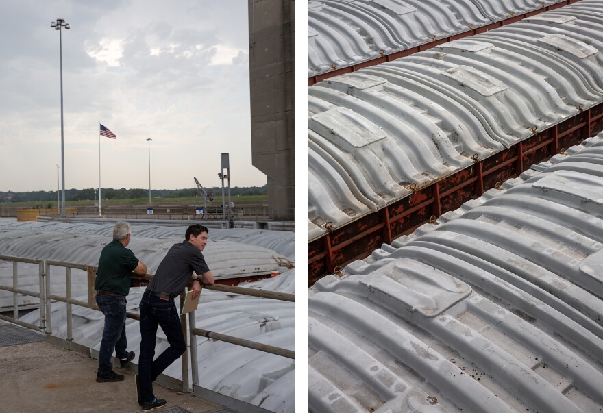 LEFT: Navigation Manager Andrew Schimpf, left, and Jose Lopez, program manager for the Lock and Dam 25 expansion project, watch as a barge is transported through a lock on Wednesday, July 26, 2023 at the Melvin Price Lock And Dam on the Mississippi River. RIGHT: Shipping containers are transported by barge through a lock on Wednesday, July 26, 2023 at the Melvin Price Lock And Dam on the Mississippi River. 