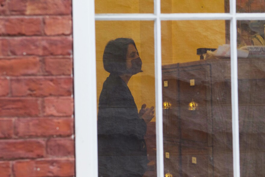 A woman in mask through a window