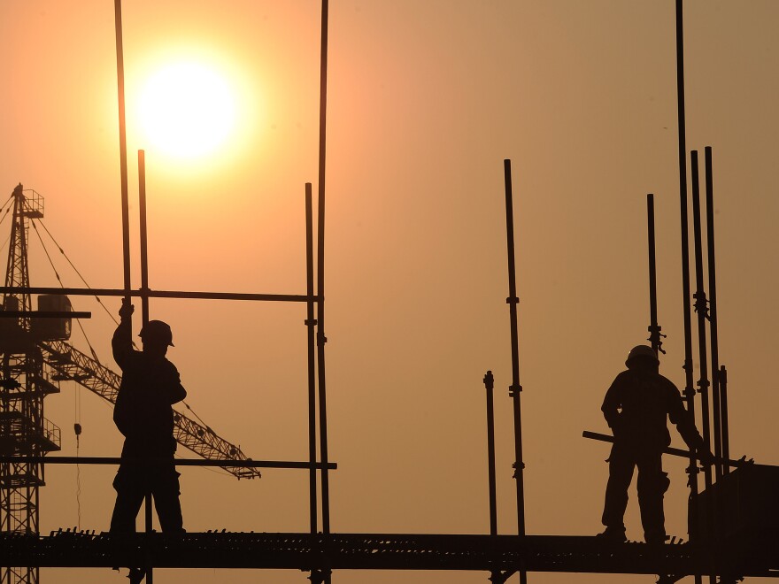 Workers scramble on a scaffold at a construction site in Hefei, central China's Anhui province, last month. China has approved a massive infrastructure package worth more than $158 billion, state media said in September, as the government seeks to boost the flagging economy.