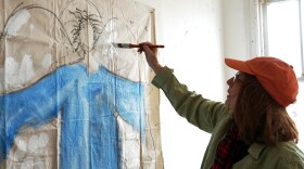 Jerre Wike-Picker of Grace Church paints a "protecting angel" on a sheet of canvas on February 2, 2019. The church is partnering with nonprofit LOVEtheLOU to restore a vacant home in the city's Vandeventer neighborhood.