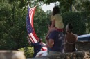 A flag hangs in front of a large crowd of people.
