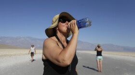 Maria Wieser, of Italy, takes a drink of water while sightseeing in Death Vally National Park, Friday, June 28, 2013 in Badwater, Calif. Excessive heat warnings will continue for much of the Desert Southwest as building high pressure triggers major warming in eastern California, Nevada, and Arizona.