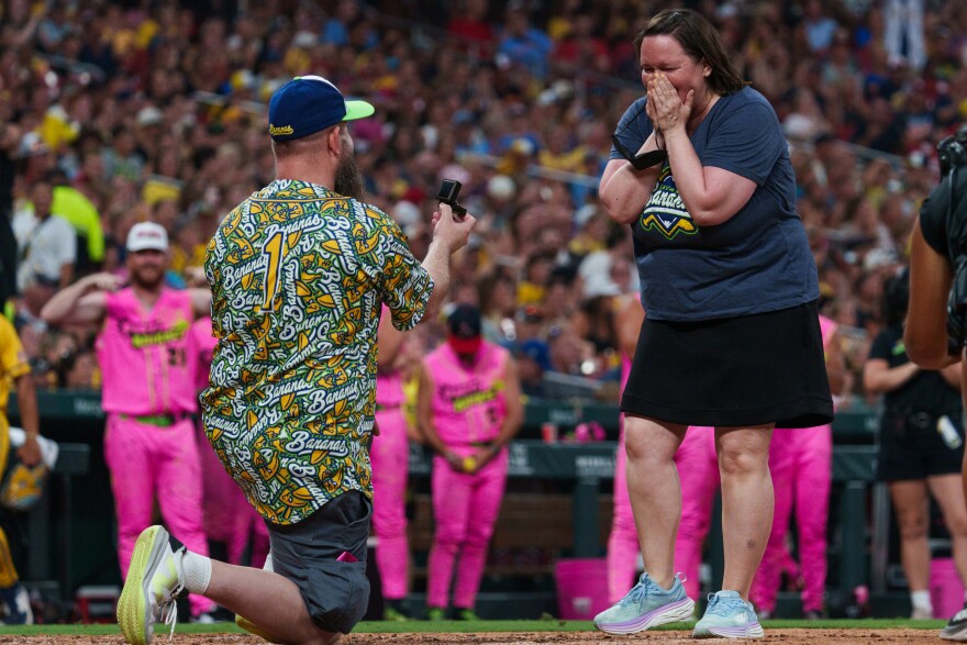 Steven Endres proposes to his girlfriend Michel King, of Farmington, Minnesota, on the home plate at Busch Stadium after doing a blindfold challenge between innings at Busch Stadium on Friday, July 18, 2025, in downtown St. Louis.