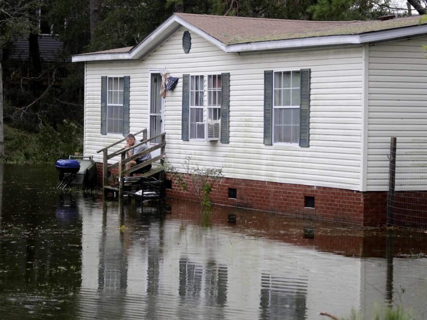 A North Carolina resident sits on his staircase earlier this week, staring into the water that surrounded his home after Florence hit Emerald Isle, N.C.