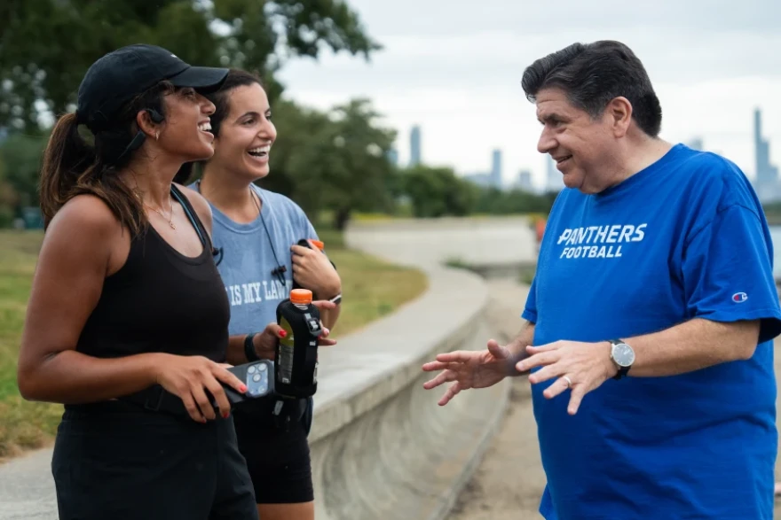 Joggers talk to Gov. J.B. Pritzker at 31st Street Beach on the South Side as he was walking by Sept. 16.