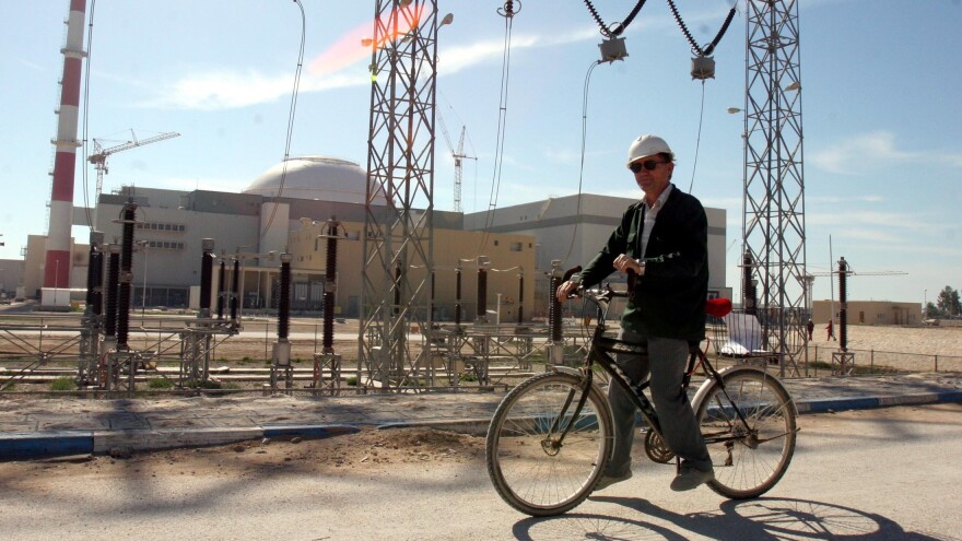 A Russian technician rides past the Iranian nuclear power plant in Bushehr.