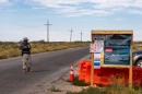 A masked guard blocks the entrance to Camp East Montana, a migrant detention facility at Fort Bliss in El Paso, Nov. 15, 2025.