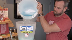 Cardinal Spirits CEO Adam Quirk pours house-made hand sanitizer into a dispenser