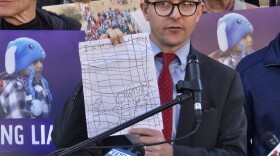 Immigration detention Attorney Eric Lee of Detroit holds up artwork drawn by A detained child that showed stick people with frowns and tears behind a wire fence