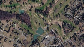 A satellite image of the golf course from Google Maps shows the irrigation pond towards the bottom of the picture, with Woods Creek running roughly northeast through the course.