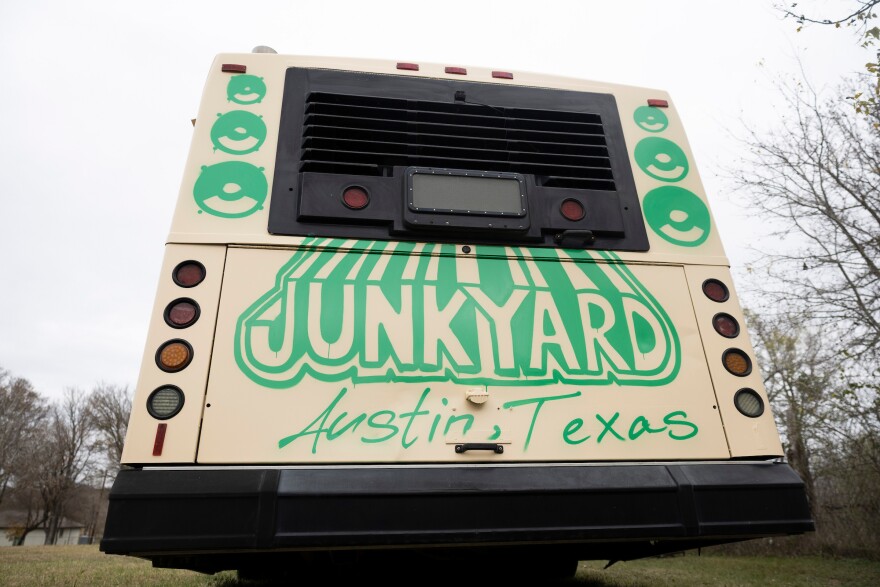 A bus painted with Junkyard, Austin, Texas,sits on a plot of land in Elgin.