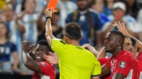 Referee Joao Pinheiro, of Portugal, gives a red card to Switzerland's Breel Embolo (7), left, during the World Cup quarterfinal soccer match between Argentina and Switzerland in Kansas City, Mo., Saturday, July 11, 2026.