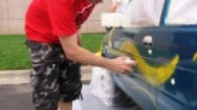 Artist-in-residence Ryan Humphrey helps students "trick out" a car in the parking lot at the Kemper Museum of Contemporary Art