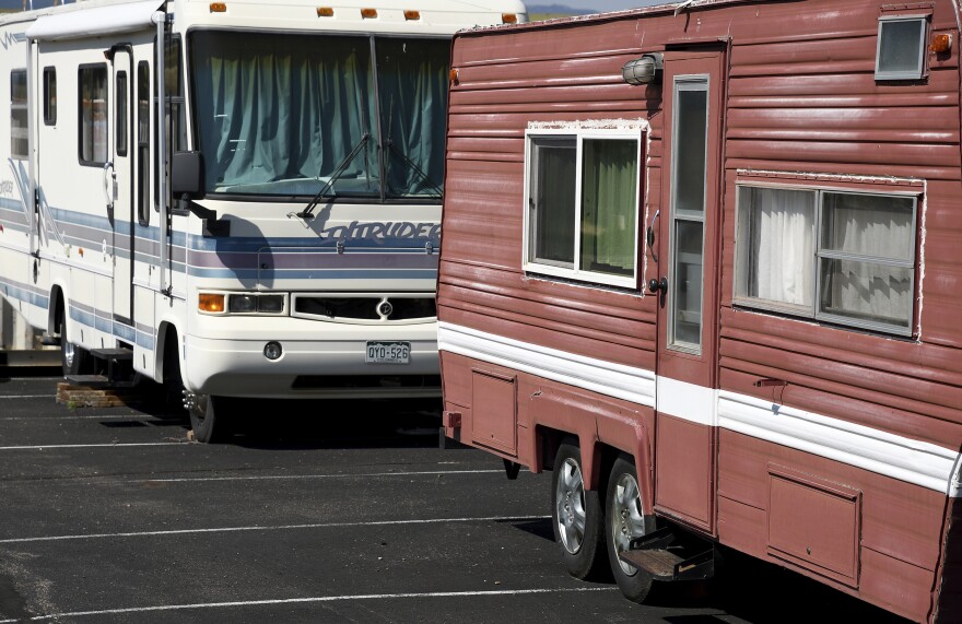 Closeup of an RV and camping trailer sitting in a church parking lot.